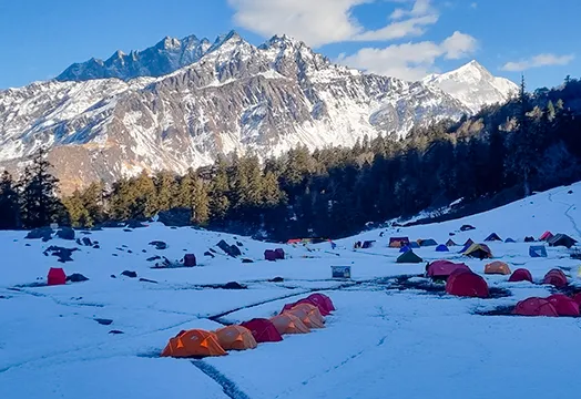 Group of trekkers sitting around a camping table inside a white tent
