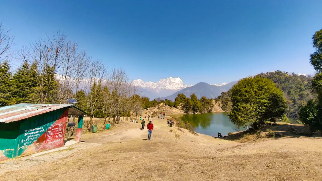 Group of trekkers sitting around a camping table inside a white tent