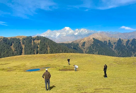 Group of trekkers sitting around a camping table inside a white tent