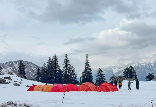 Group of trekkers sitting around a camping table inside a white tent