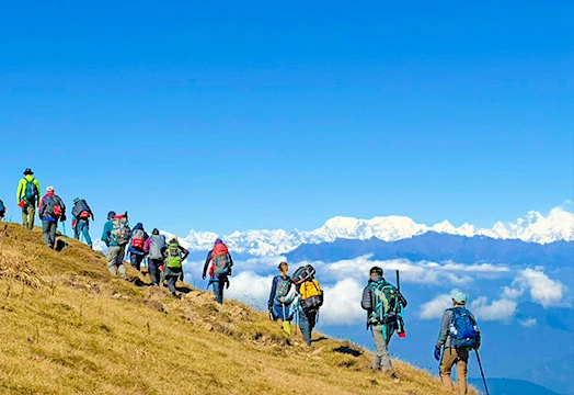 Group of trekkers sitting around a camping table inside a white tent