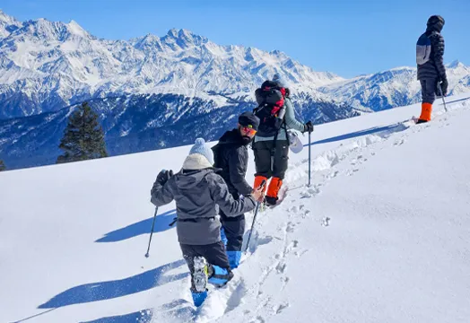 Group of trekkers sitting around a camping table inside a white tent