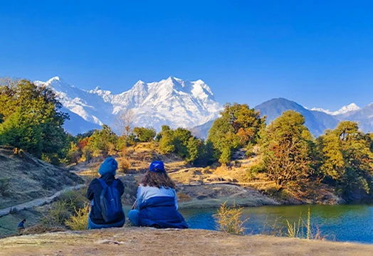 Group of trekkers sitting around a camping table inside a white tent