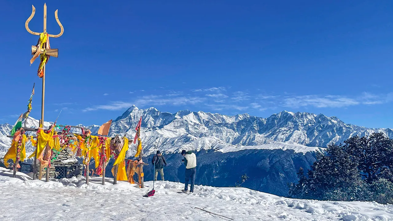 Trekkers enjoying at the brahmatal trek near prayer flags, Trek The Himalayas