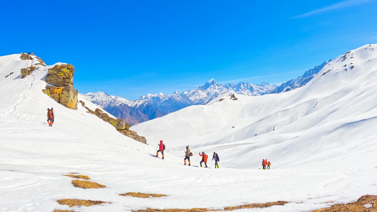 Trekkers hiking through the scenic Landscapes of kuari pass