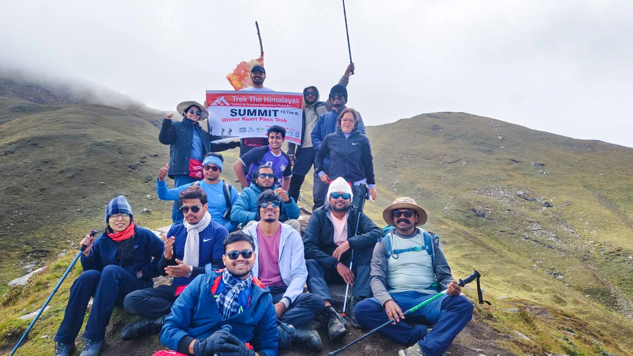 Trekkers celebrating Winter Kuari Pass Trek summit at 12,750 ft with Trek The Himalayas