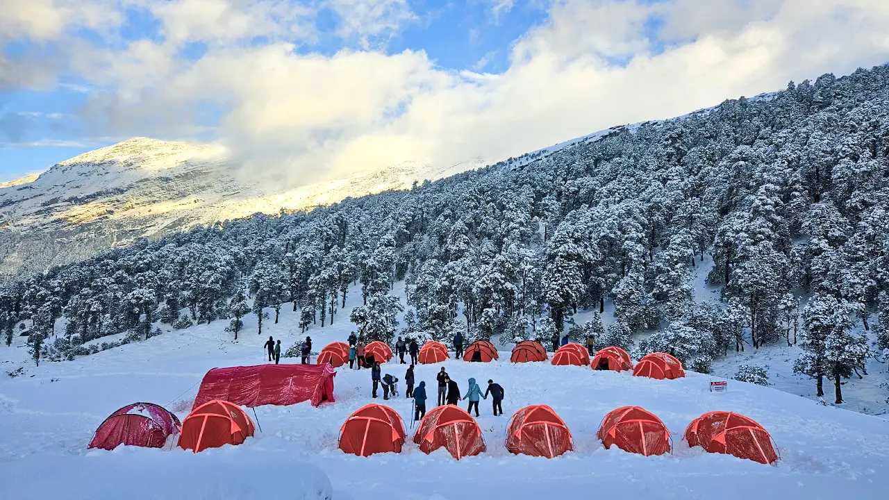 Trekkers enjoying the beauty of Brahmatal trek in winter season at campsite of Trek The Himalayas