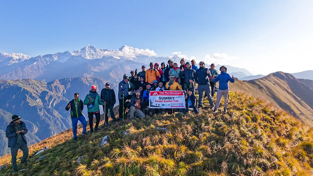 Trekkers posing with summit banner at Gulabi Kantha Trek